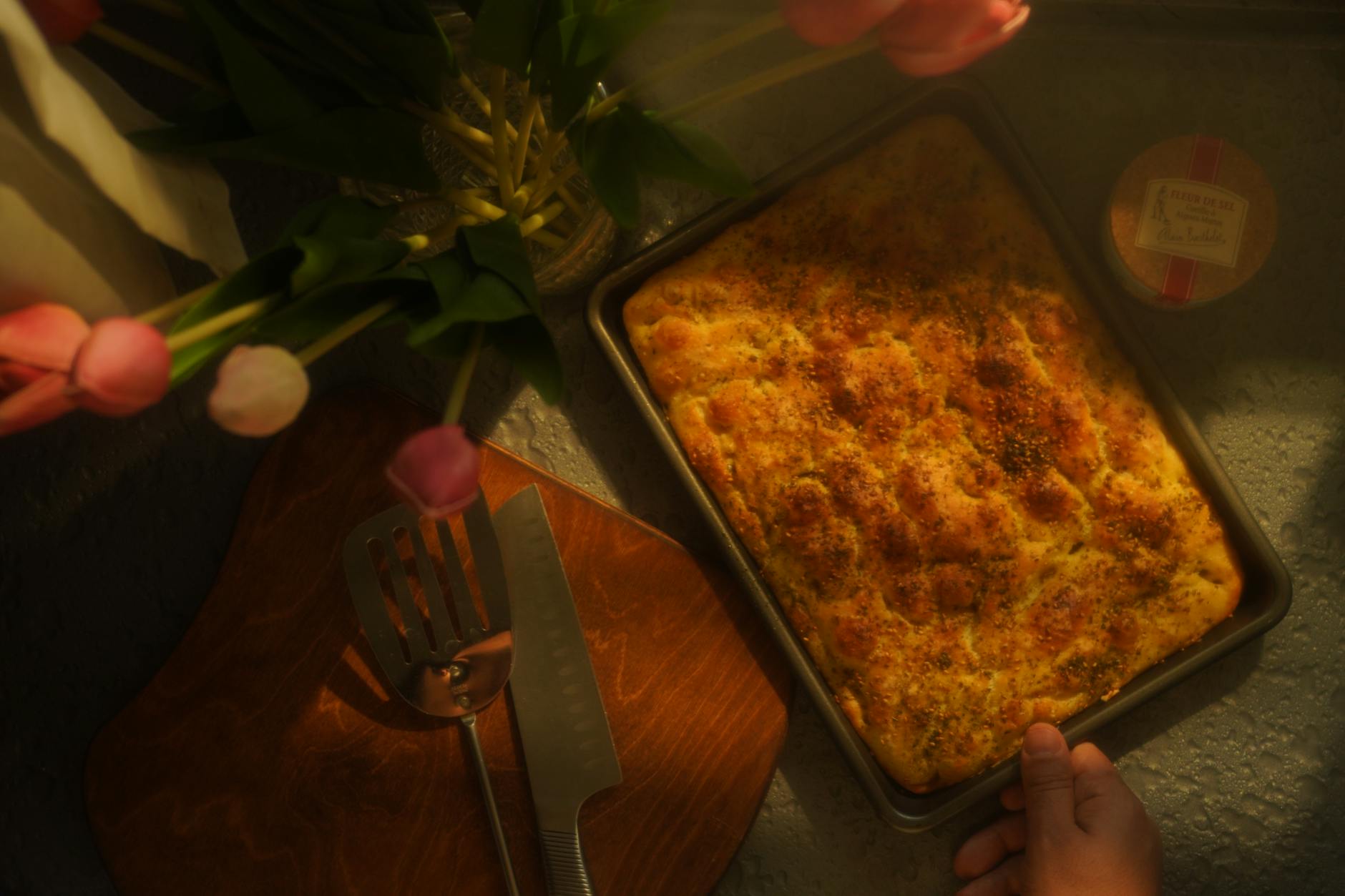 Ciepła kuchnia i świeżo upieczona focaccia na drewnianym blacie