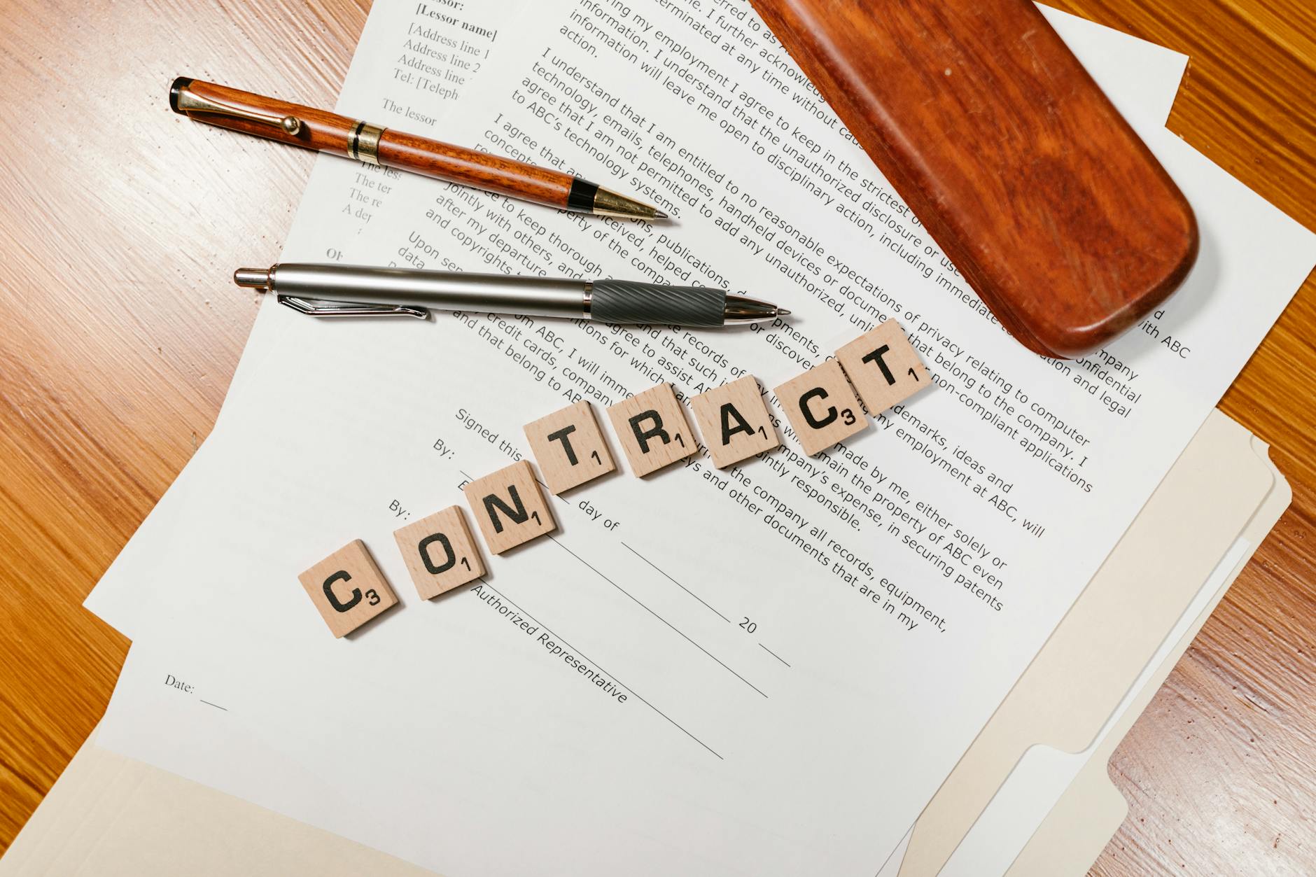 Zbliżenie na umowę z literkami scrabble układającymi się w słowo CONTRACT