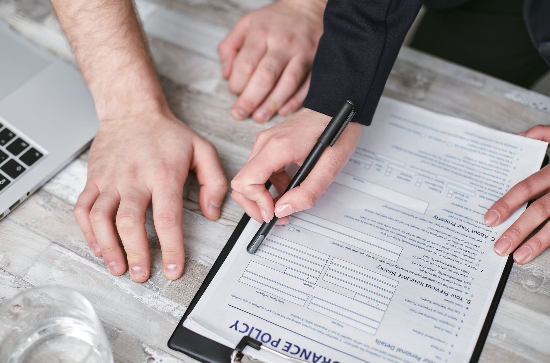 Przedsiębiorcy podpisują umowę ubezpieczenia firmy przy biurku Przedsiębiorcy podpisują umowę ubezpieczenia firmy przy biurku