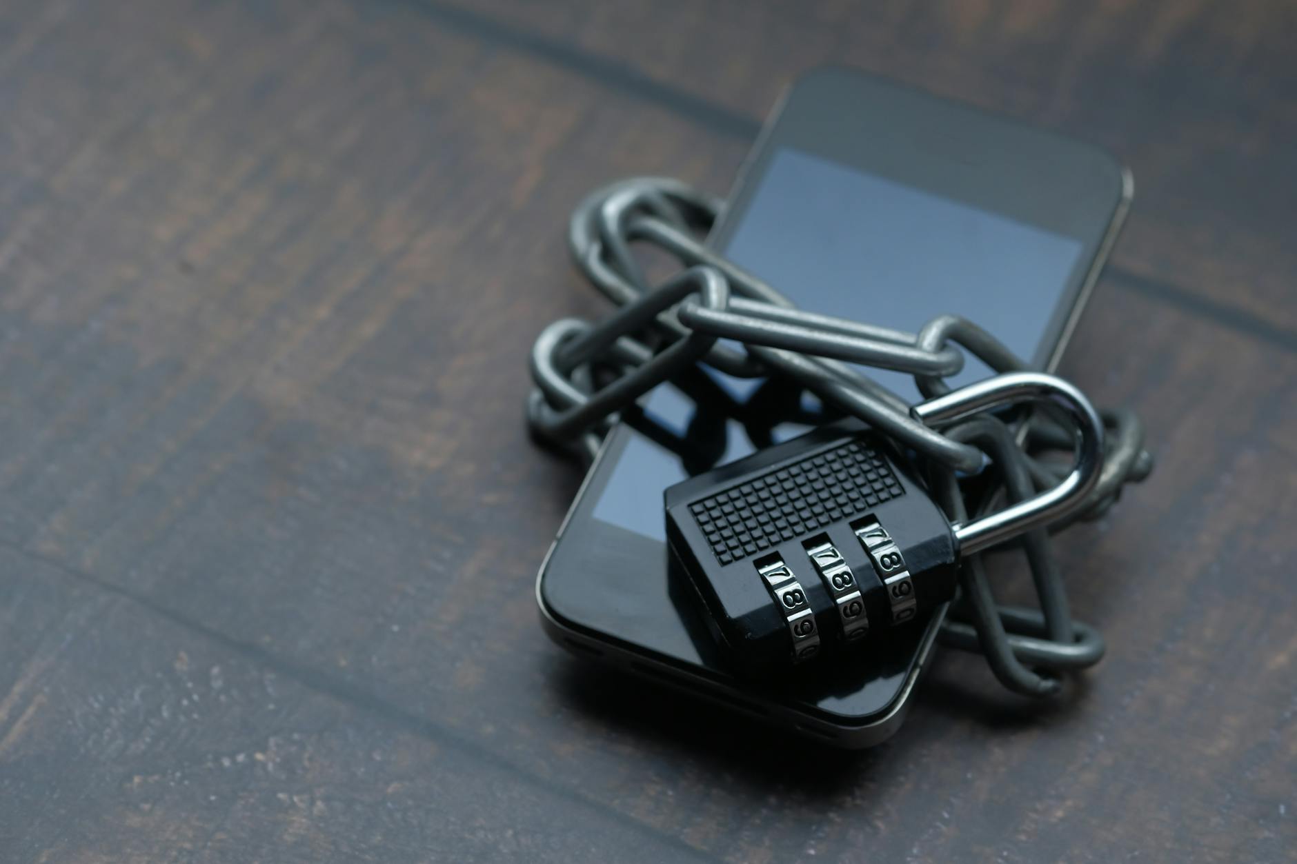 Smartfon opleciony łańcuchem z kłódką jako symbol ochrony danych
